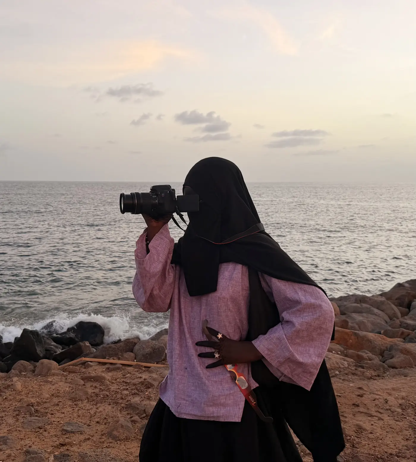 Penda Carlol photographie au bord de l'océan au coucher du soleil, appareil à l'œil