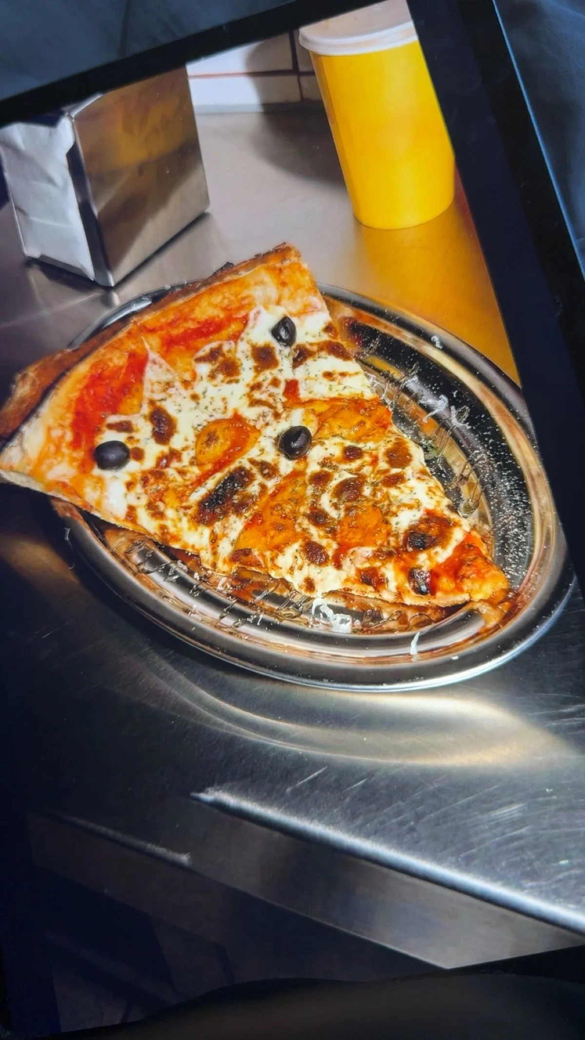 Part de pizza présentée sur un plateau métallique