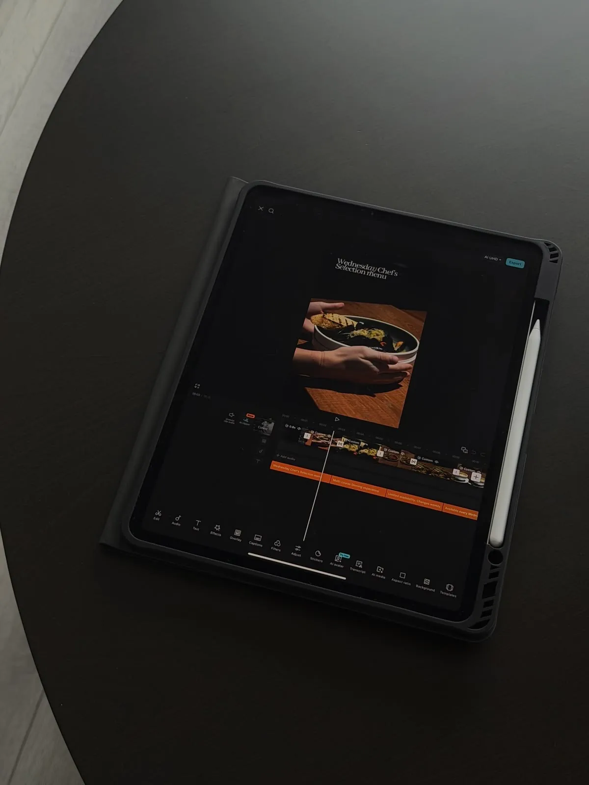 Tablette posée sur une table noire, montage vidéo d'un menu de restaurant en cours